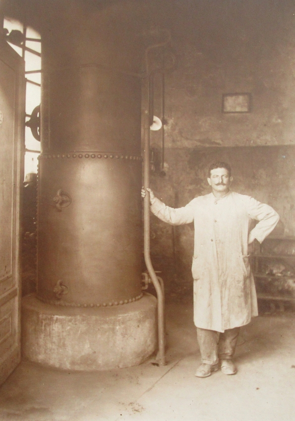 Macello Pubblico - Collezione Biblioteca Comunale G. D. Romagnosi: 1922 citca. Operaio comunale di fianco alla caldaia a vapore (Album Municipio di Salsomaggiore, le provvidenze del Comune in ordine di servizi pubblici)