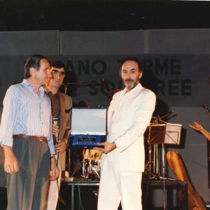 Piergiorgio Farina in Concerto -  Collezione Biblioteca Comunale G.D. Romagnosi: 8 agosto 1988 Arena degli Spettacoli - Il musicista riceve un premio dal presidente della Pro Loco di Tabiano Sig. Becchi